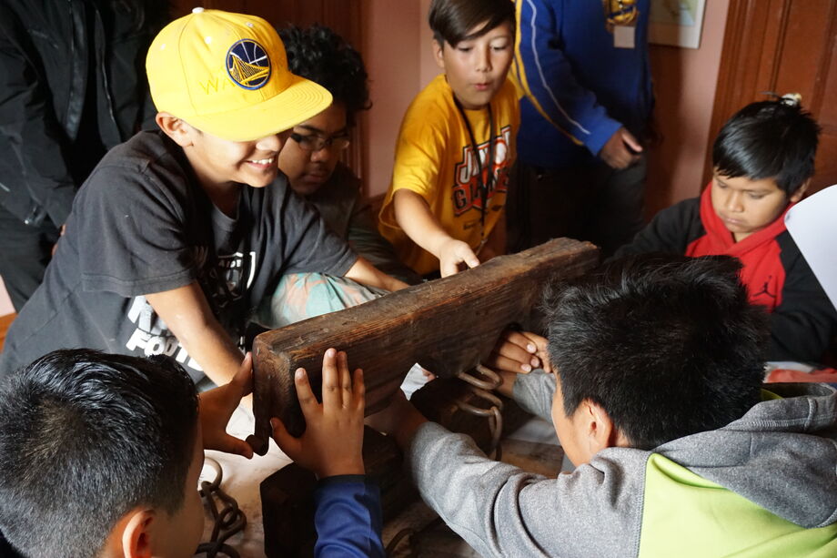 A school group examines the historic stocks at Peralta Hacienda. Image courtesy of Peralta Hacienda Historical Park.