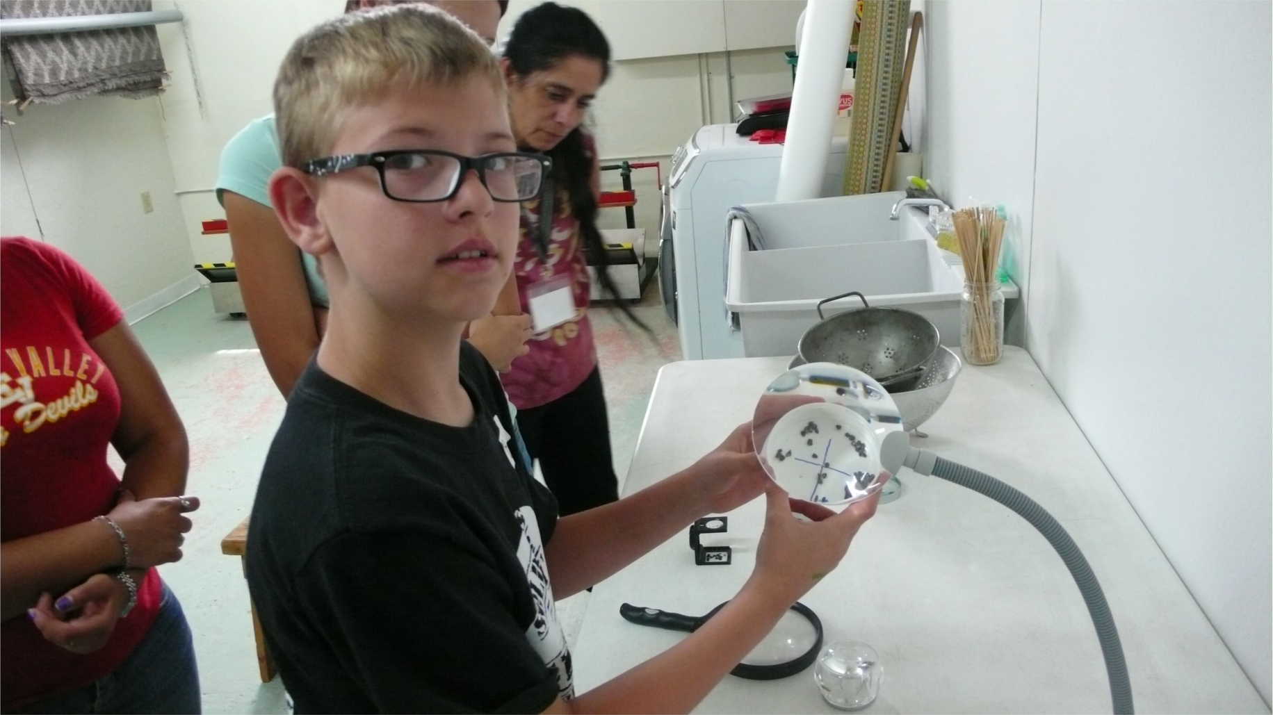 Youth examine cochineal bugs. Image courtesy of the Museum of International Folk Art.