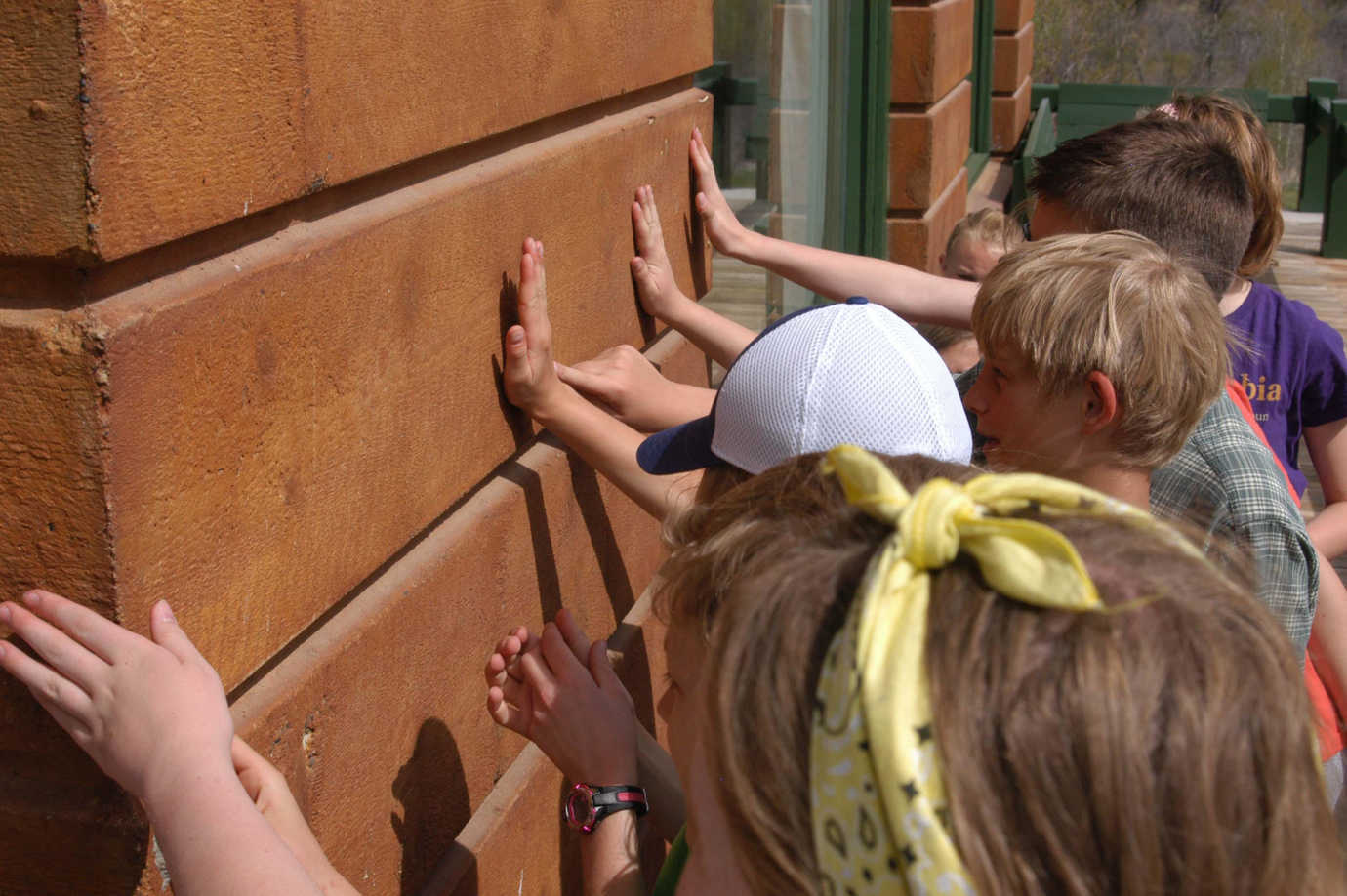 Students from a local school touch the Hemingway House, familiarizing themselves with its distinct construction. Image courtesy of the Community Library.