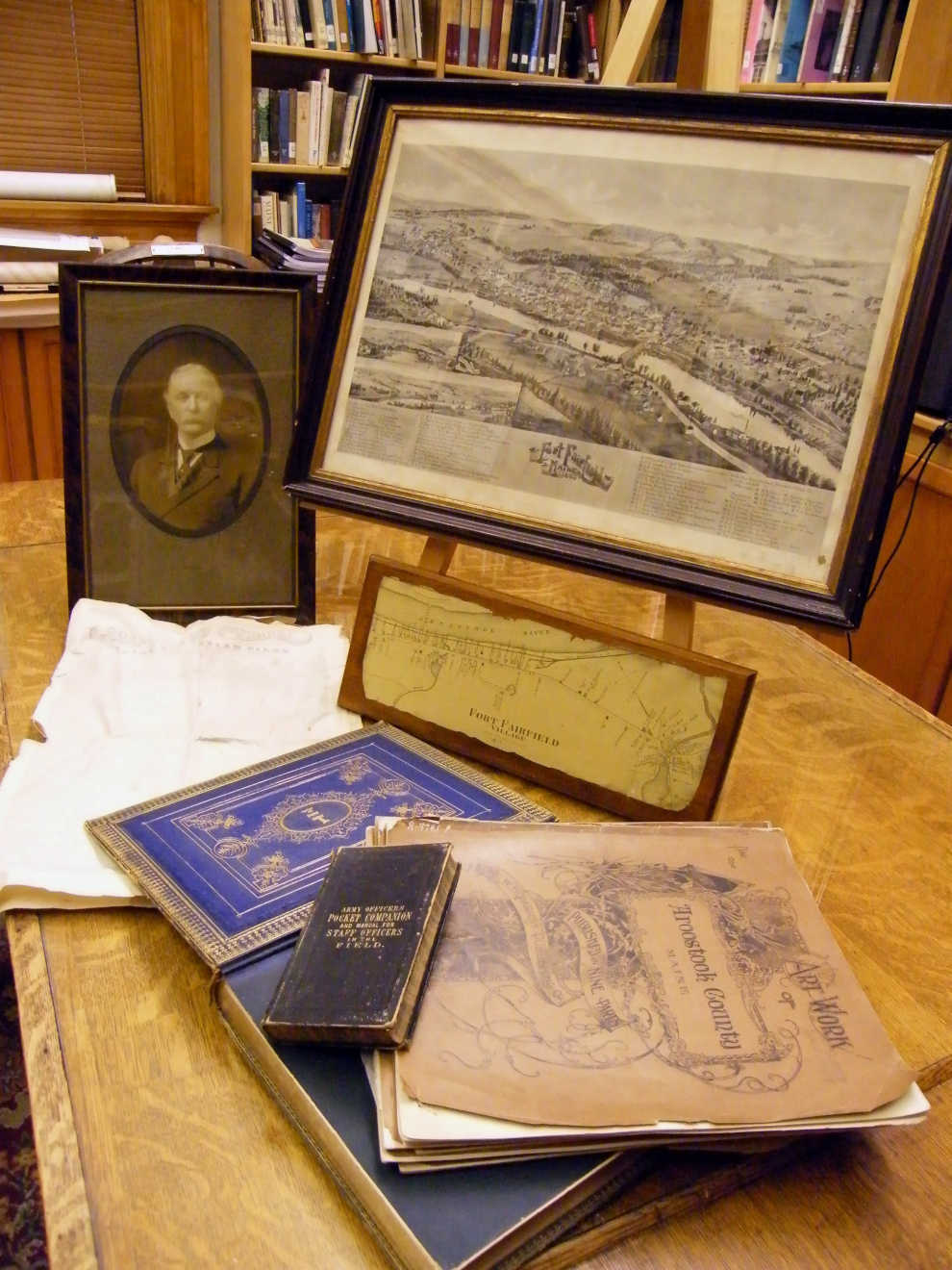 A photo of Colonel Franklin Drew with his Civil War field manual and historic maps and sketches of Fort Fairfield and the surrounding area. Photo courtesy of Fort Fairfield Public Library.