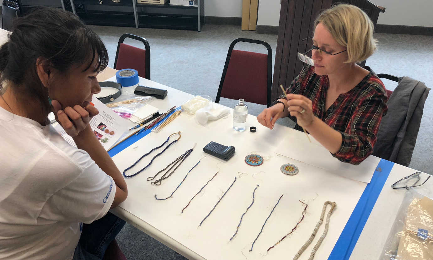 A conservator from the Midwest Art Conservation Center leads a workshop on cleaning glass bead objects. Image courtesy of the Midwest Art Conservation Center.