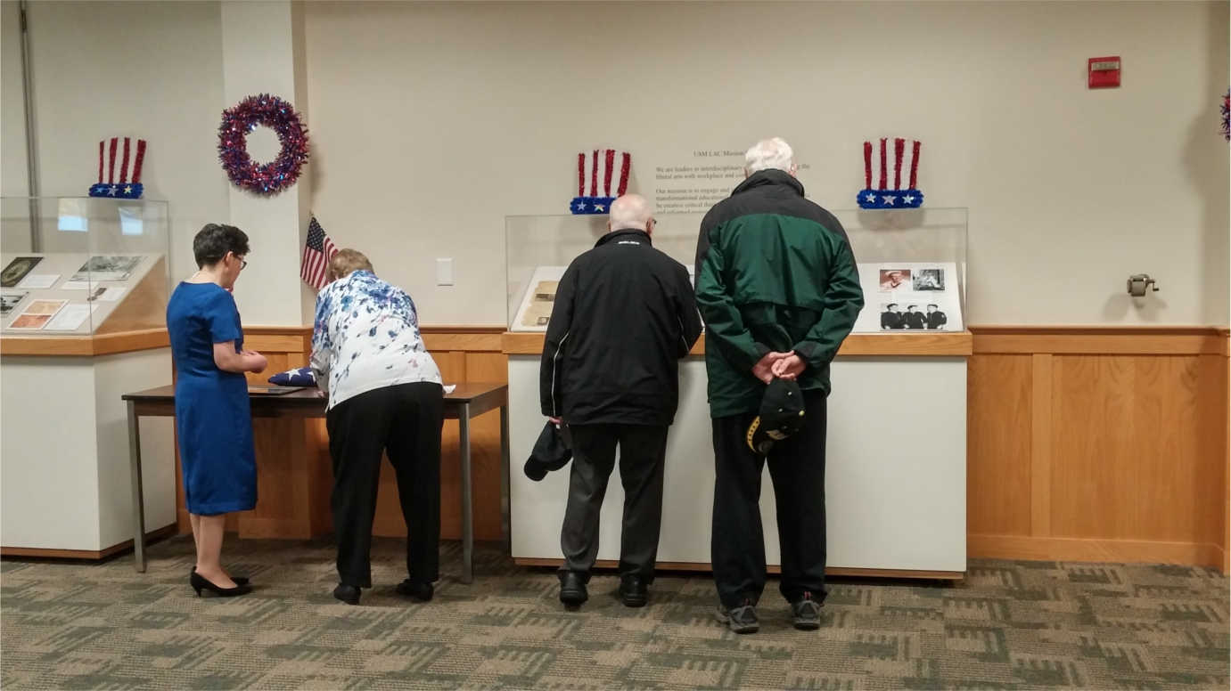 Community members view an exhibition showcasing items collected by the Franco-American Collection. Image courtesy of the Franco-American Collection.
