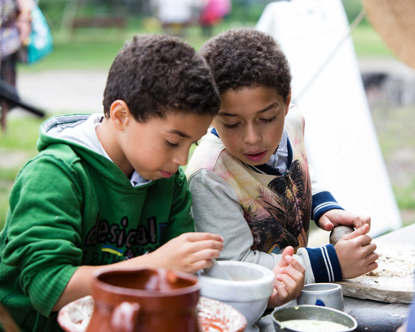 Two children examine a mortar and pestle—commonly used in eighteenth-century cooking and medicine. Image courtesy of Historic Hudson Valley.