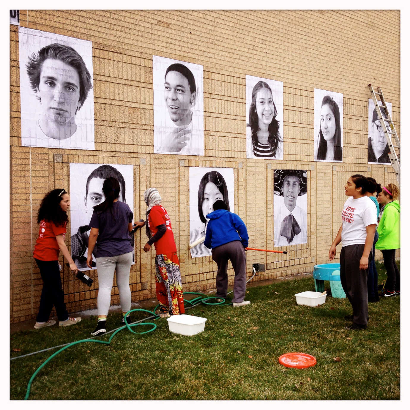 Students work together to post the representative photos of their classmates to a prominent exterior wall of the school. Photo courtesy of Trisha Empey.