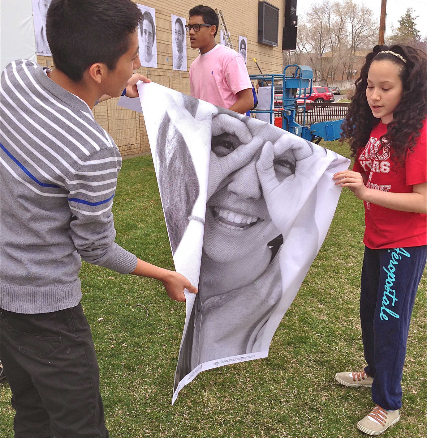 Students work together to post the representative photos of their classmates to a prominent exterior wall of the school. Photo courtesy of Trisha Empey.