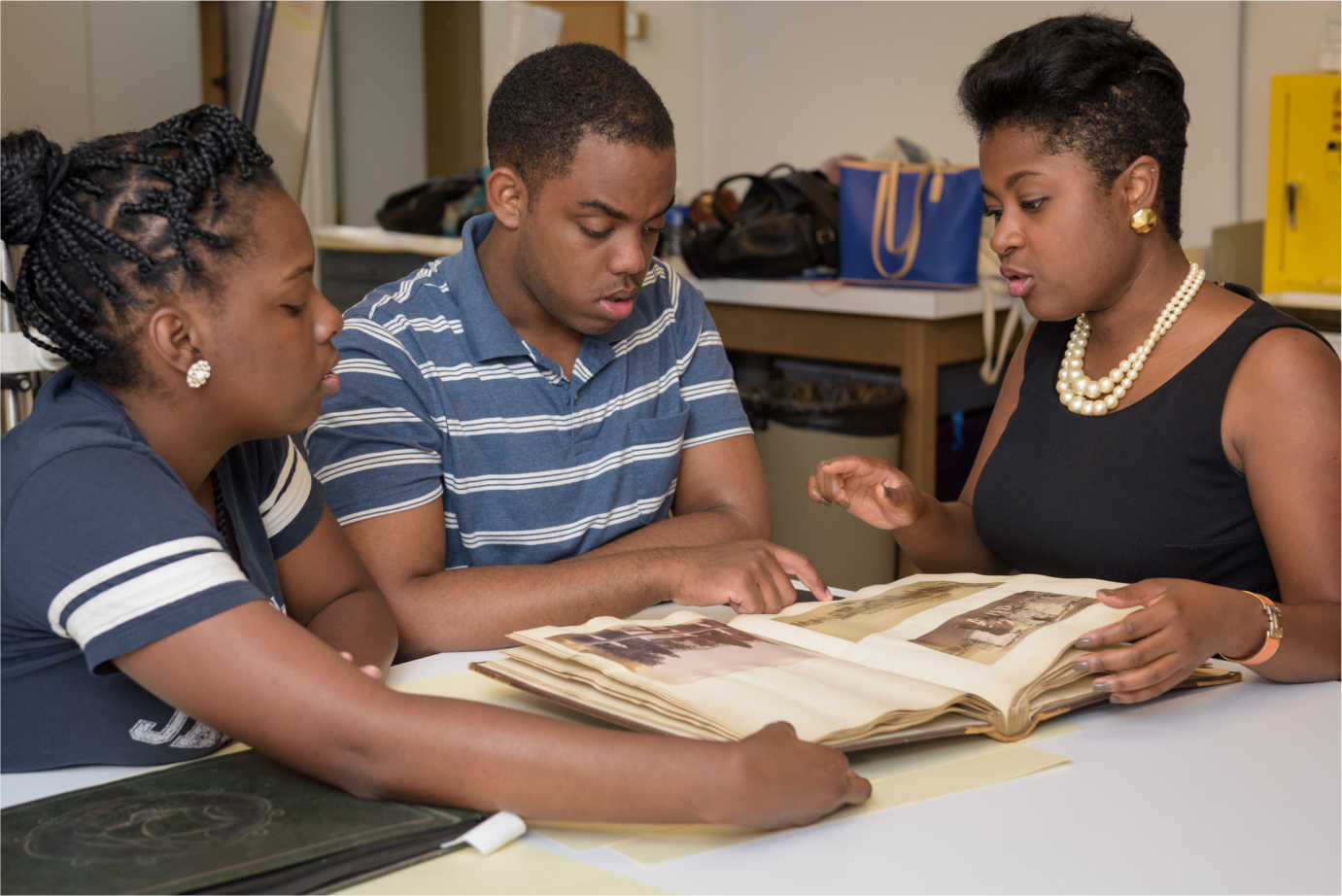 A third-year Master’s student in the Winterthur/University of Delaware Program in Art Conservation (left) examines a 19th-century photographic album with two students during a UD seminar focused on the preservation of the rich and varied photographic collections in historically black colleges and universities. Image courtesy of Evan Krape, University of Delaware.