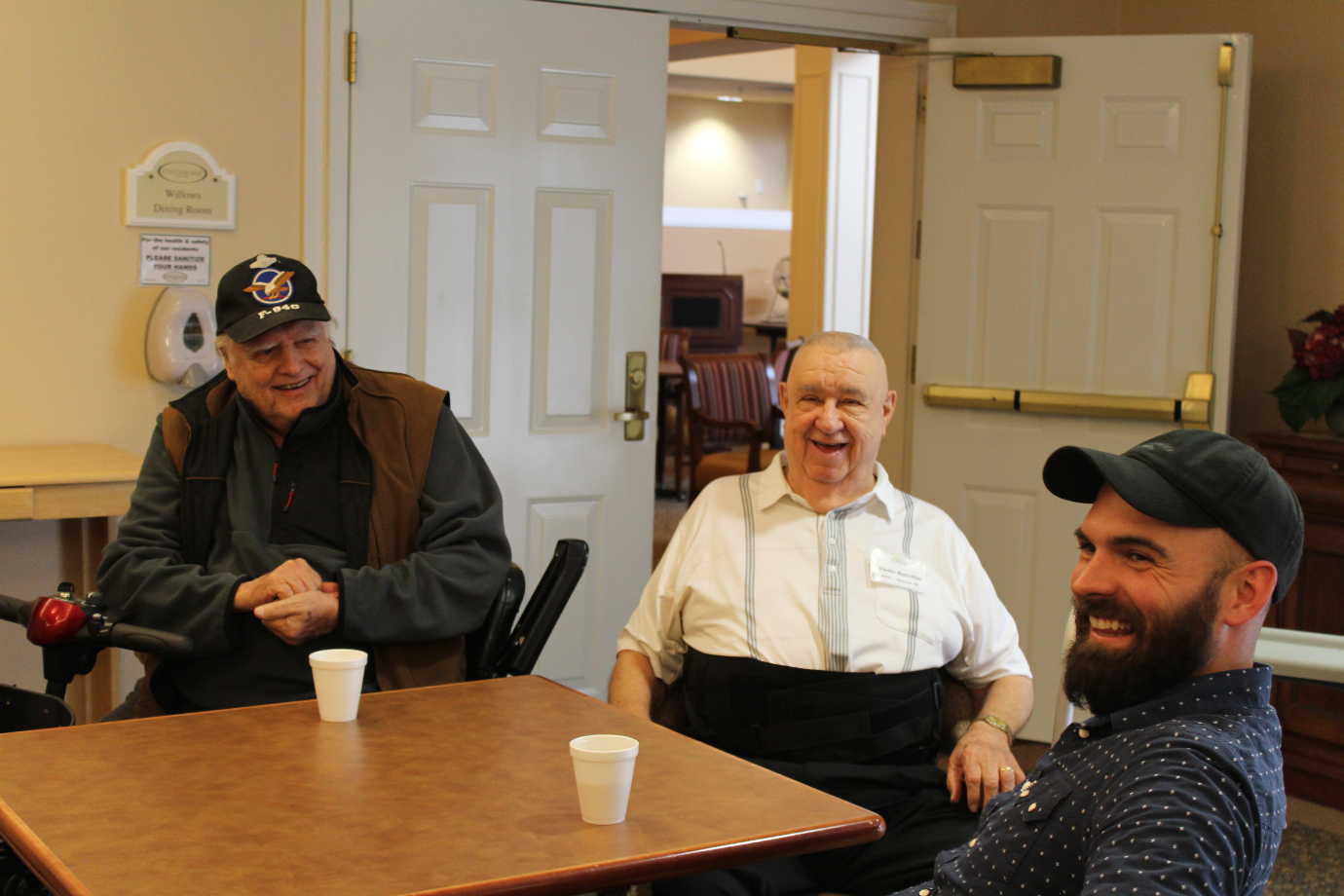 Project Unpack helped veterans make connections across generations. Here, two Vietnam veterans engage in lively conversation with Josh Zeiss, an artist and veteran of Iraq. Image courtesy of Project Unpack.